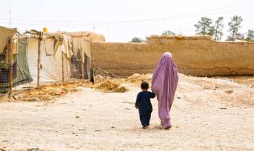 Una madre camina de la mano con su hijo en Afganistán