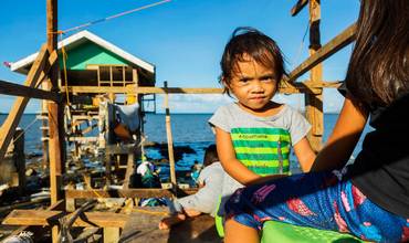 Un niño filipino enfrente del hogar familiar que ya han empezado a reconstruir
