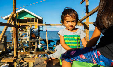 Un niño filipino enfrente del hogar familiar que ya han empezado a reconstruir