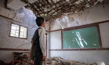Un niño contempla las ruinas de su escuela en Hajjah