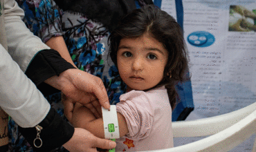 Personal sanitario en Afganistán mide la circunferencia del brazo de una niña