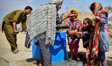 Familia disfrutando de una fuente de agua instalada por UNICEF