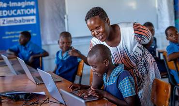Alumnos con ordenadores portátiles en Zimbabue
