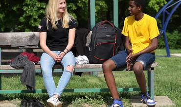 Voluntaria conversando con joven refugiado de Info Park