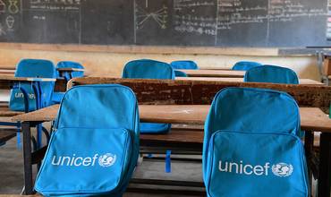 Aula de escuela con mochilas de UNICEF