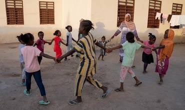 Halima tomada de la mano con las niñas