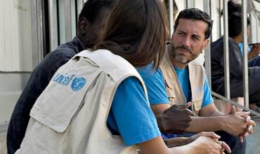 Miembros del staff de UNICEF hablan con una persona refugiada