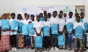 Grupo de niños y niñas en una escuela con mochilas UNICEF