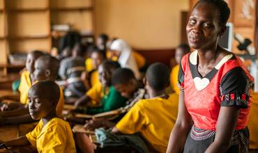 Imagen de una mujer con jóvenes en una escuela
