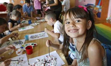 Una niña sonríe mientras trabaja en un aula de primaria