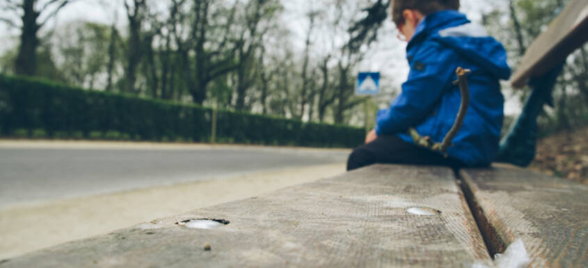 Un niño sentado en un banco.