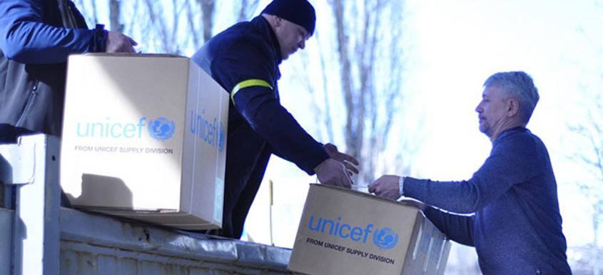 Imagen de dos trabajadores de UNICEF descargando cajas con suministros