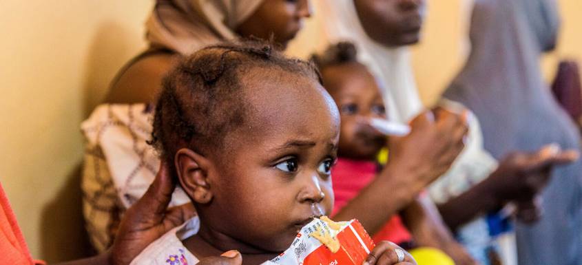 Una niña toma alimento terapéutico contra la desnutrición.