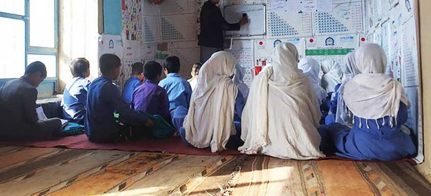 Estudiantes en aula con profesor Sadiq en Daykundi, Afganistán