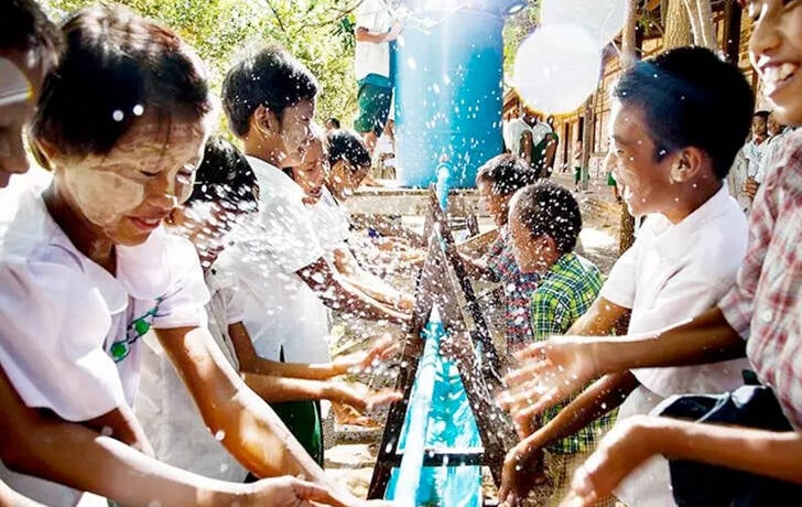 Un grupo de niños se lavan las manos