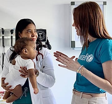 Un bebé mira con atención a staff de UNICEF