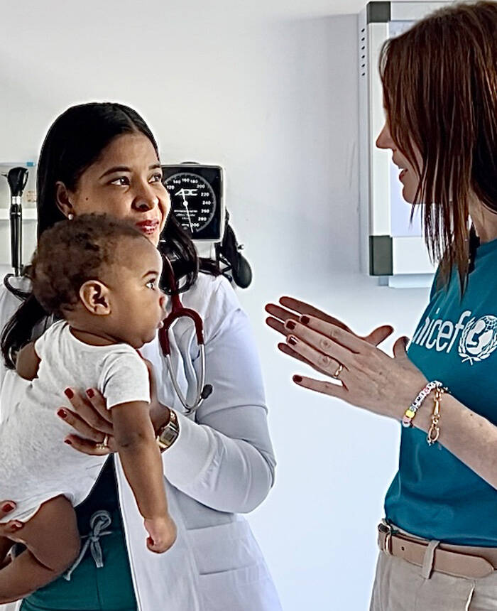 Un bebé mira con atención a staff de UNICEF