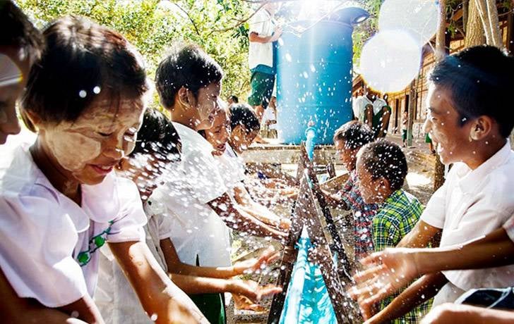 Varios niños felices lavándose las manos