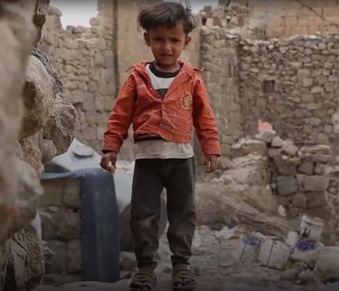 Un niño jugando sobre escombros