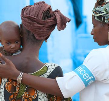Una colaboradora UNICEF ayuda a una madre con su bebé