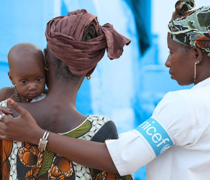 Una colaboradora UNICEF ayuda a una madre con su bebé