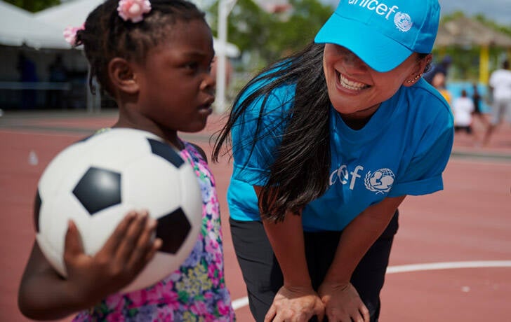 Una niña evacuada el huracán Dorian participa en actividades organizadas por IsraAid, organización socia de UNICEF Una niña juega con un balón de futbol
