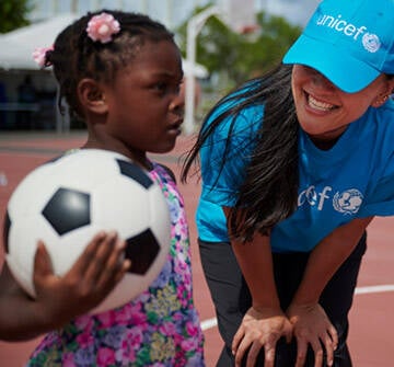 Una niña evacuada el huracán Dorian participa en actividades organizadas por IsraAid, organización socia de UNICEF Una niña juega con un balón de futbol