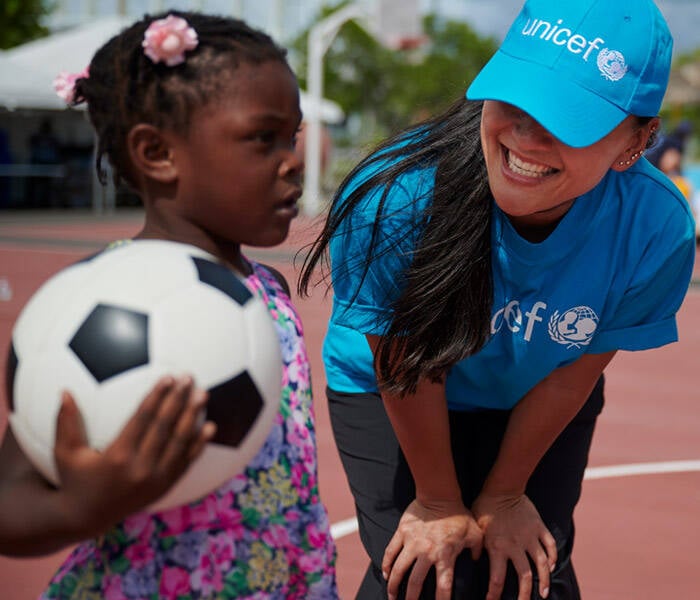 Una niña evacuada el huracán Dorian participa en actividades organizadas por IsraAid, organización socia de UNICEF Una niña juega con un balón de futbol