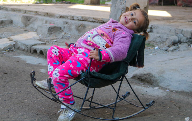 Amneh, de 3 años, sentada en una hamaca frente a su casa en las afueras de la ciudad de Deir-ez-Zor, al noreste de Siria, el 6 de febrero de 2024.