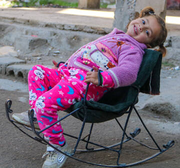Amneh, de 3 años, sentada en una hamaca frente a su casa en las afueras de la ciudad de Deir-ez-Zor, al noreste de Siria, el 6 de febrero de 2024.