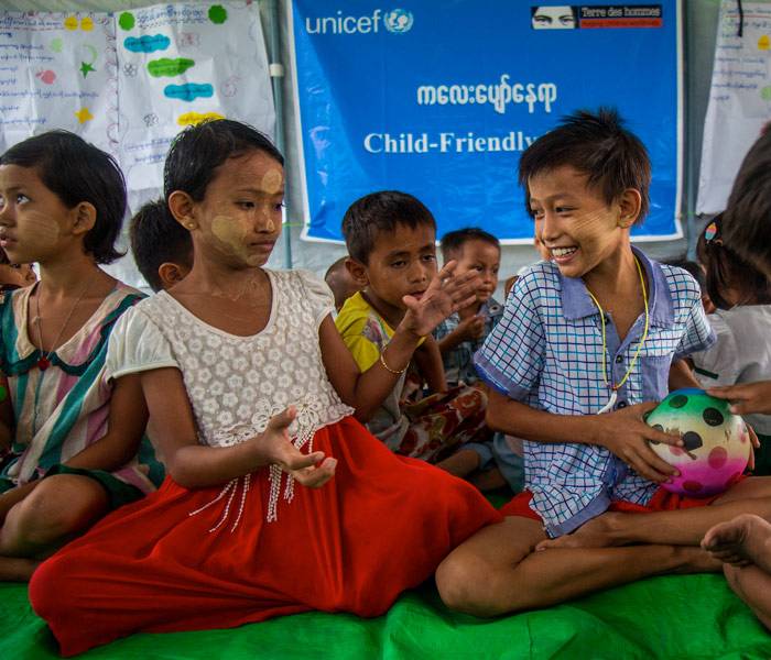 Niños juegan dentro de una tienda de campaña adaptada a los niños proporcionada por UNICEF.