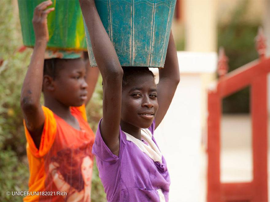 Millones de niñas y mujeres en todo el mundo no disponen de acceso a agua potable Dos niñas cargan bidones de agua