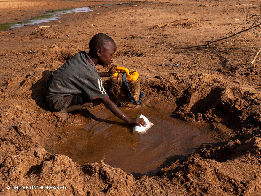 Un niño en Somalia intenta coger agua de un río seco por las duras sequías que están asolando el país. Un niño busca agua