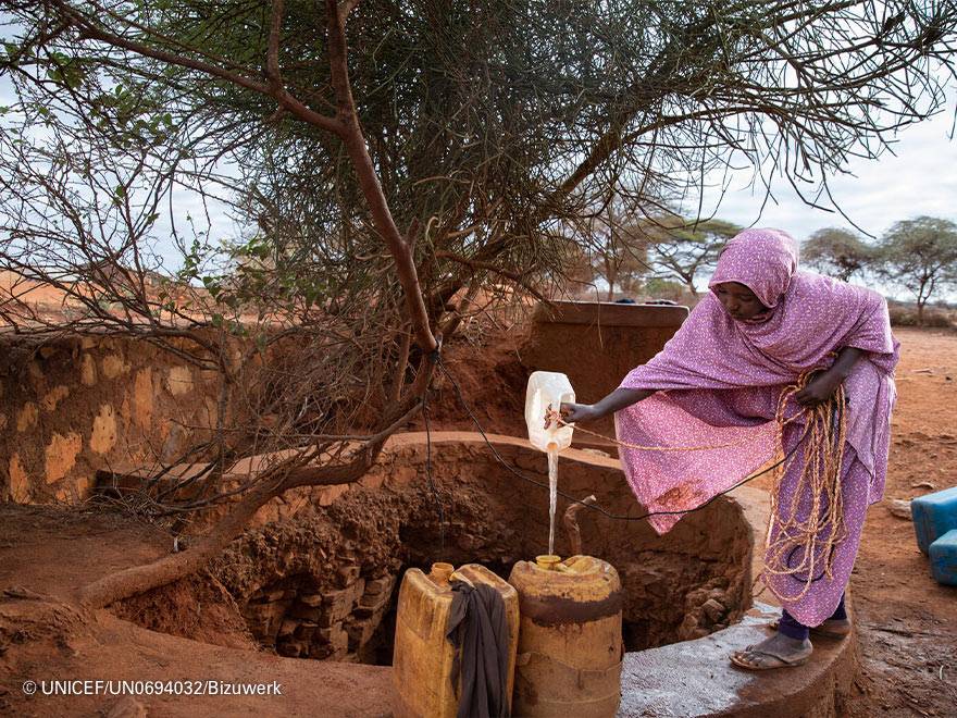 Una mujer recoge agua Una mujer recoge agua