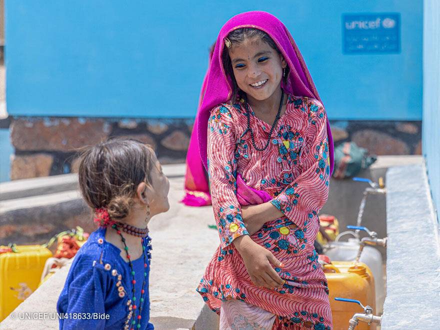 Dos niñas frente a una toma de agua Dos niñas frente a una toma de agua