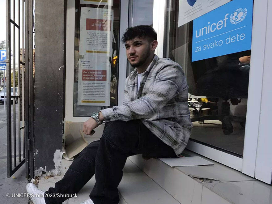 UNICEF_ Srbija_2023_Shubuckl Un joven iraquí refugiado en Serbia, esperando a que abran las puertas de la ONG donde aprende el idioma local