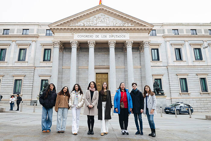 Los chicos y chicas participantes posan frente a la fachada del Congreso de los Diputados