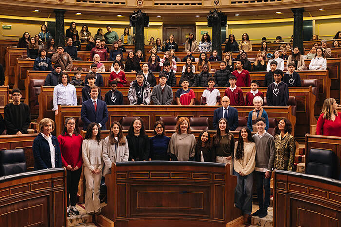 Los chicos y chicas participantes posan desde el hemiciclo, junto a la Presidenta del Congreso y otros diputados y diputadas