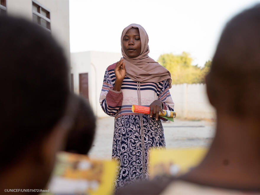 Halima, durante uno de los talleres en los que imparte. Halima habla a otras personas.