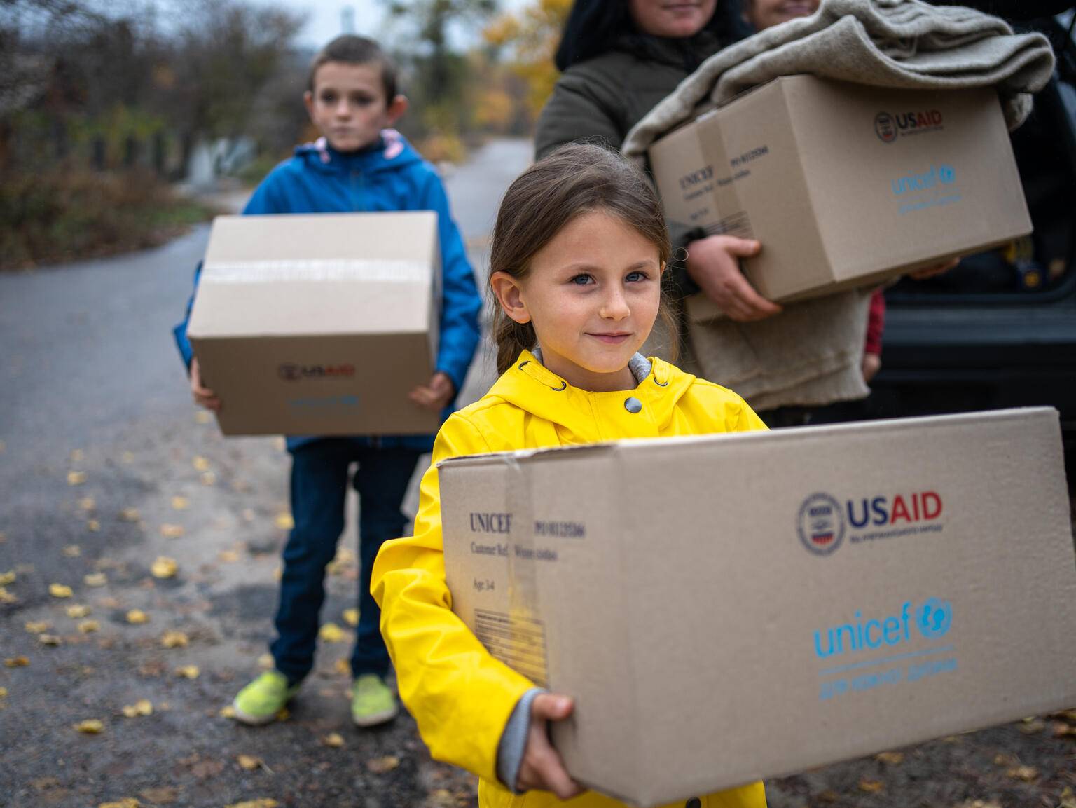 Dos niños ucranianos con las cajas de ayuda humanitaria que está repartiendo UNICEF