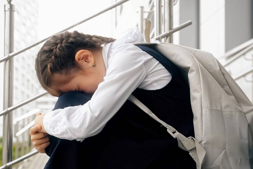 Una niña sentada en las escaleras