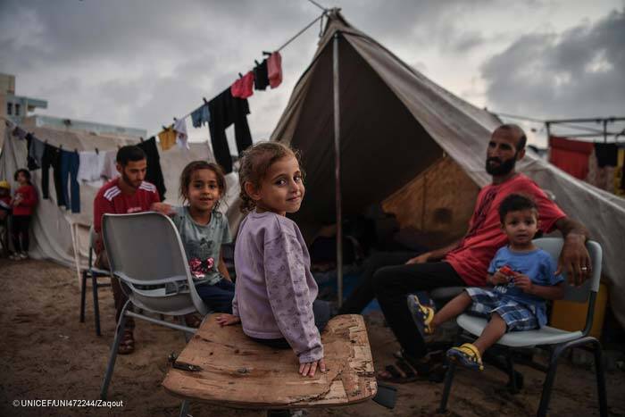 Familia reunida delante de su tienda en un campo de desplazados en Gaza