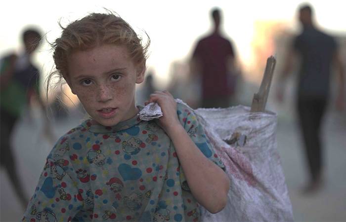 Una niña en Gaza acarrea una bolsa con sus pertenencias