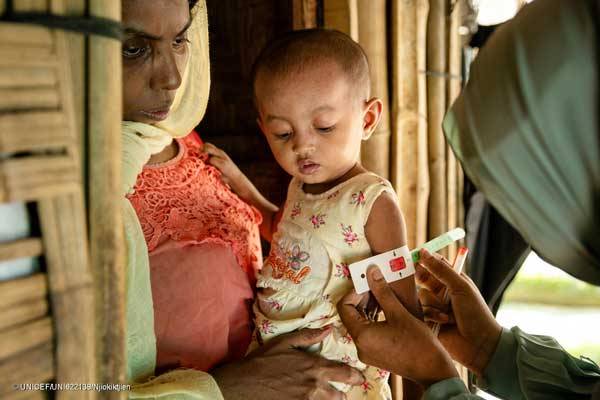 El 16 de julio de 2024, Taslima, voluntaria de nutrición de la comunidad rohingya, visita a Rubeda, de 28 años, para proporcionar asesoramiento nutricional y evaluar el estado nutricional de su hija Sofiba, de 2 años, en su refugio de los campos de refugiados rohingya de Cox's Bazar, Bangladesh.