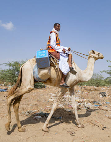 Mahmoud monta en camello para acceder a los niños durante la campaña de vacunación contra la polio puerta a puerta en el valle de Barqiq. Mahmoud, un vacunador y trabajador de la salud en la remota localidad de Agig.