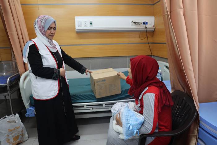 Una madre recibe ropa para su bebé.