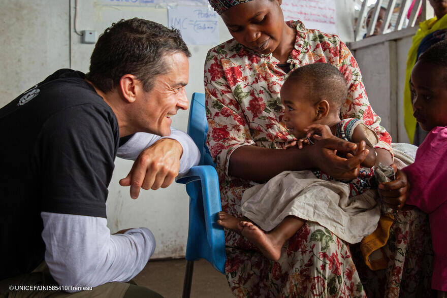El 1 de junio de 2024, Orlando Bloom, Embajador de Buena Voluntad de UNICEF, saluda a un niño durante una visita al centro Bushagara para desplazados internos en las afueras de Goma, al este de la República Democrática del Congo.