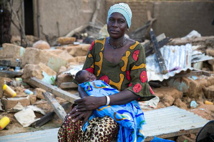 Una madre con su bebé afectados por las inundaciones en África.