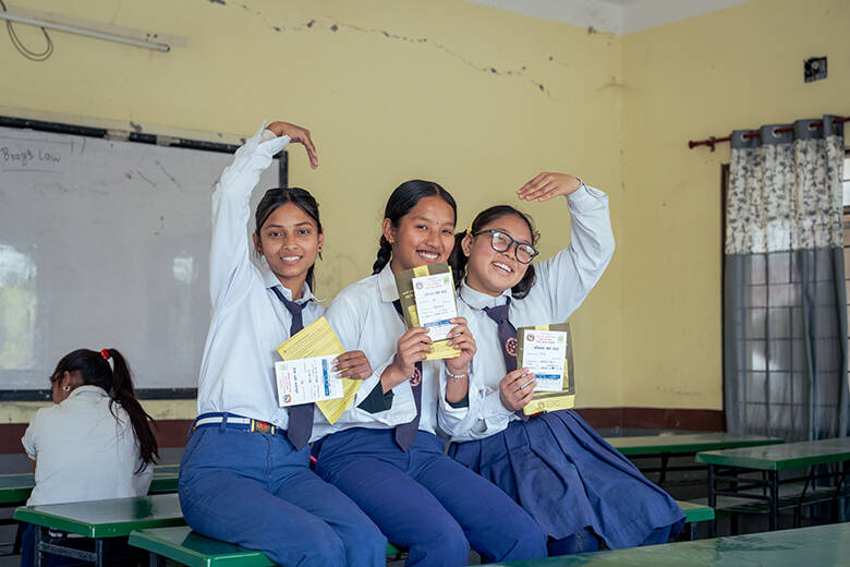 Tres estudiantes de Nepal muestran sus cartillas de vacunación tras recibir la dosis contra el VPH. Tres estudiantes de Nepal muestran sus cartillas de vacunación tras recibir la dosis contra el VPH.