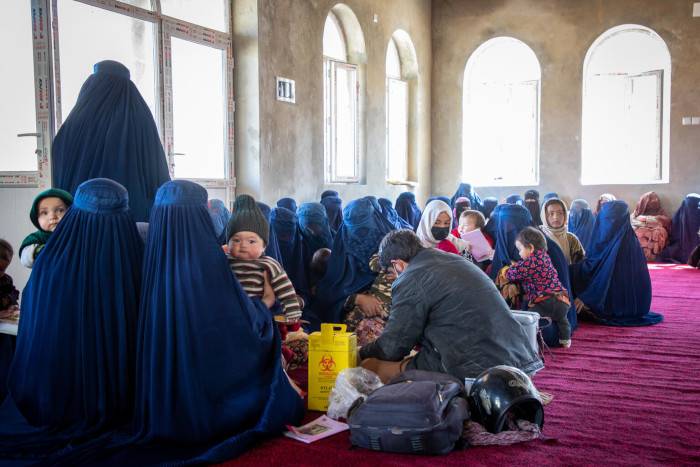 Madres llevan a sus hijos al punto de vacunación.